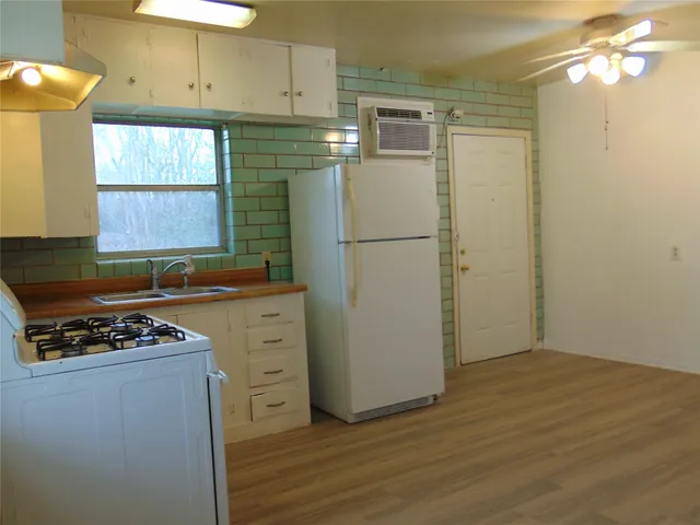 a kitchen with cabinets appliances a sink and a window