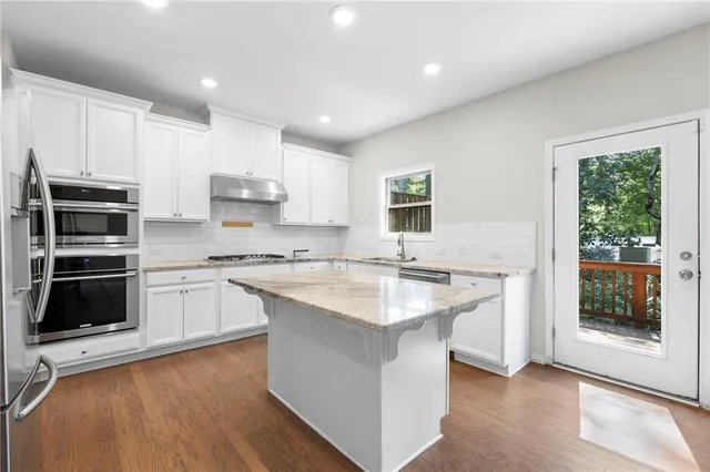 a kitchen with stainless steel appliances granite countertop a sink stove and refrigerator