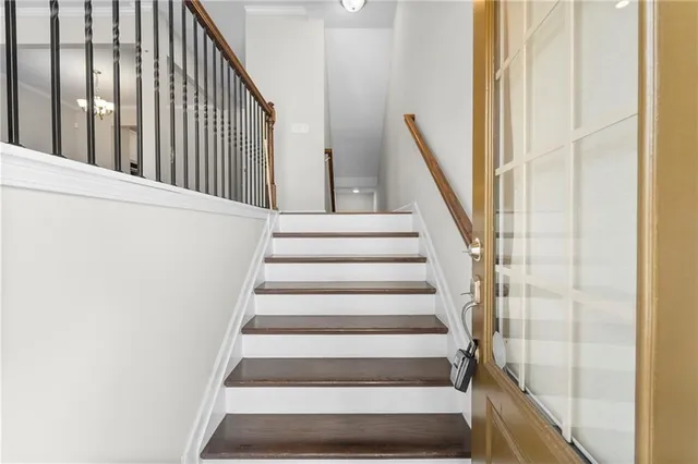 a view of staircase with railing and white walls