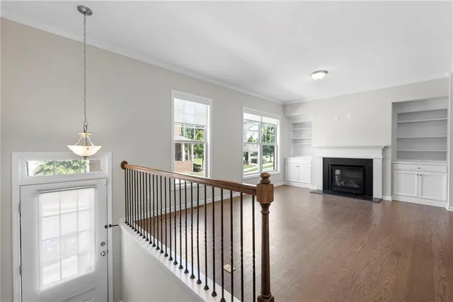 a view of empty room with fireplace and wooden floor