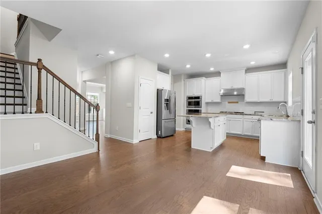 a open kitchen with white cabinets and stainless steel appliances