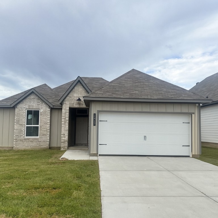 a front view of a house with a garden and garage