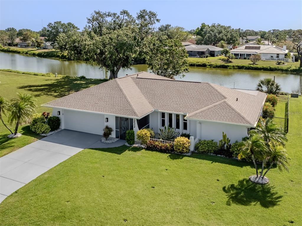 an aerial view of a house with swimming pool and lake view