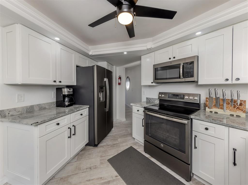 1232 Pine Needle Road Venice, FL 34285 - Photo 12 of 91 a kitchen with stainless steel appliances granite countertop a stove sink microwave and refrigerator