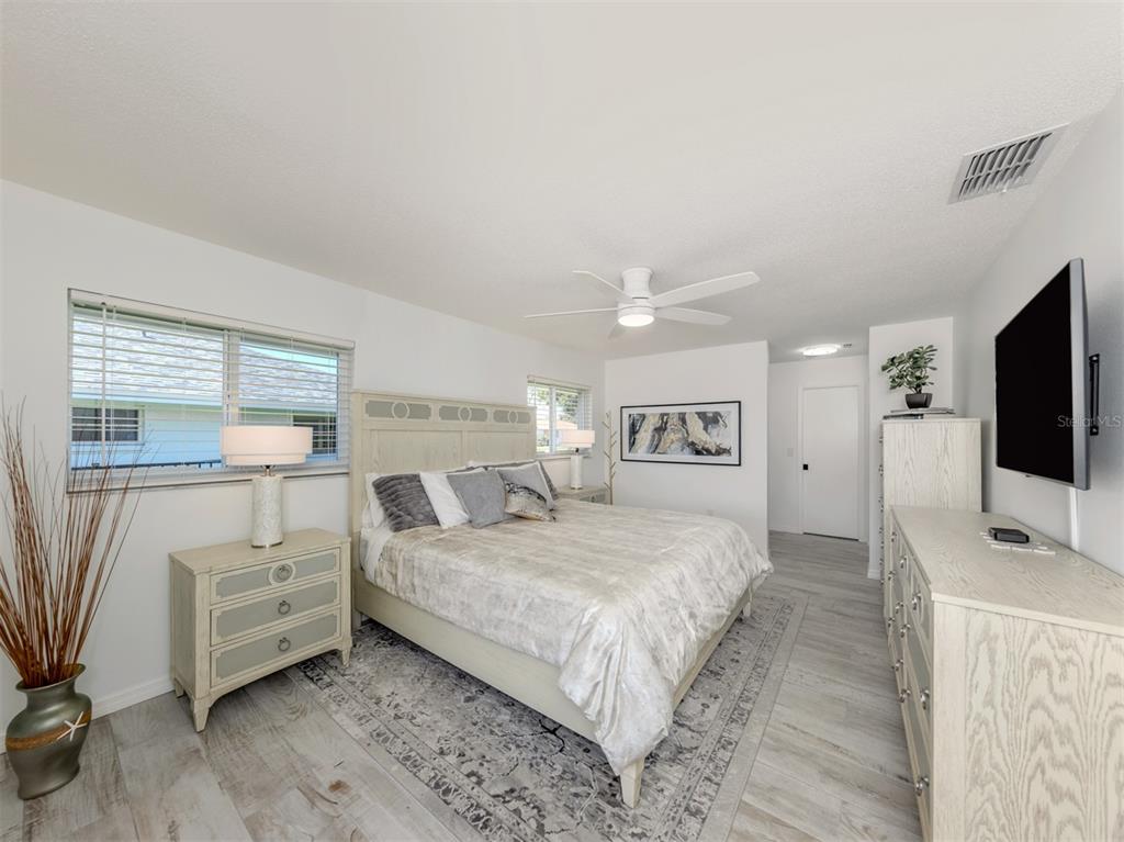 1232 Pine Needle Road Venice, FL 34285 - Photo 32 of 91 a bedroom with a bed and a flat tv screen on wall