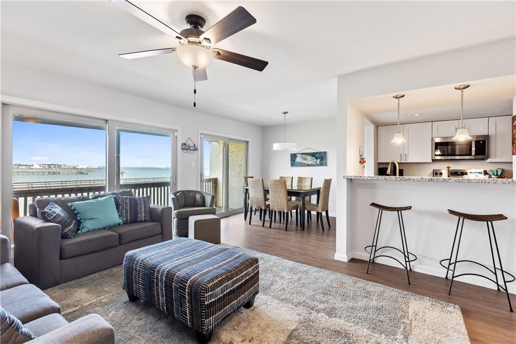 a living room with furniture and a dining table with kitchen view