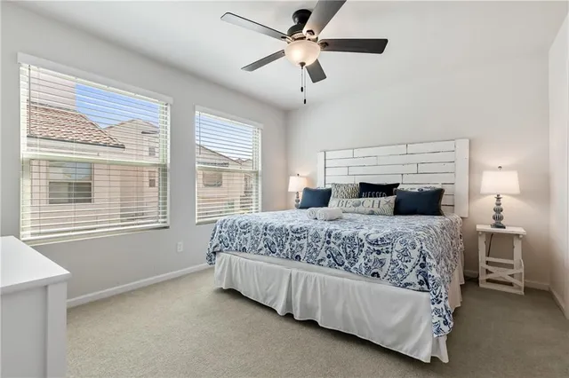 a bedroom with a large bed and a chandelier fan