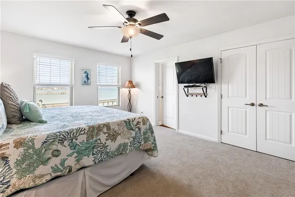 a spacious bedroom with a bed and a flat screen tv