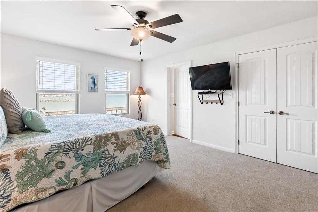 620 Fulton Beach Road, Unit 308 Rockport, TX 78382 - Photo 20 of 30 a spacious bedroom with a bed and a flat screen tv