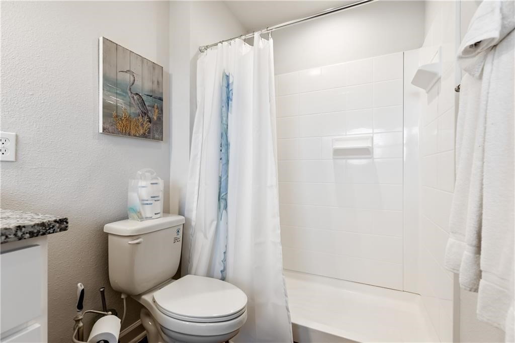 620 Fulton Beach Road, Unit 308 Rockport, TX 78382 - Photo 22 of 30 a white toilet sitting next to a bathroom sink