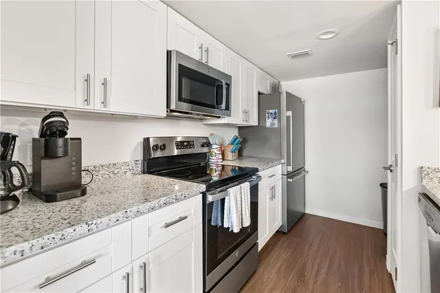 a kitchen with stainless steel appliances granite countertop a stove a sink and a microwave