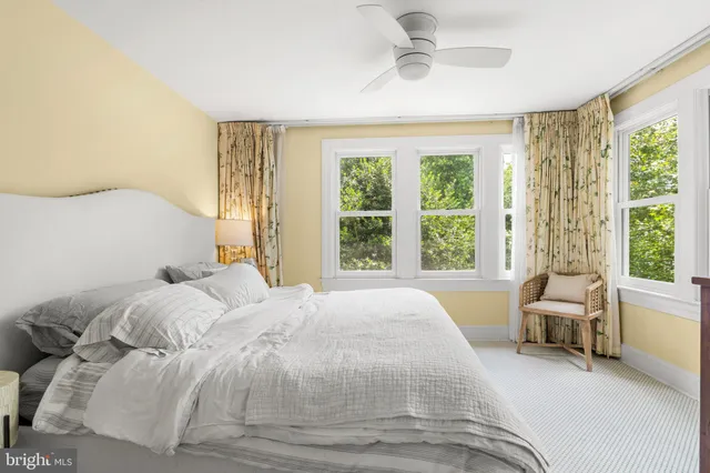 a view of a bedroom with baby crib and a window