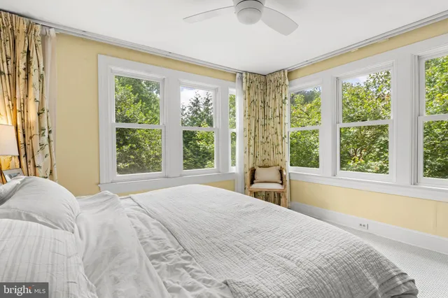 a bedroom with a bed and large windows