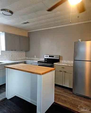 a kitchen with stainless steel appliances granite countertop a refrigerator a sink and a stove