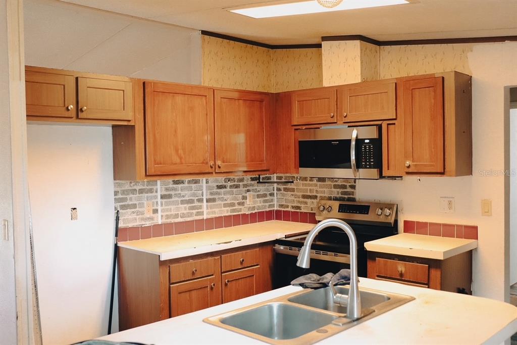 448 Fernandez Street Winter Haven, FL 33880 - Photo 4 of 27 a kitchen with stainless steel appliances a sink a stove and a microwave