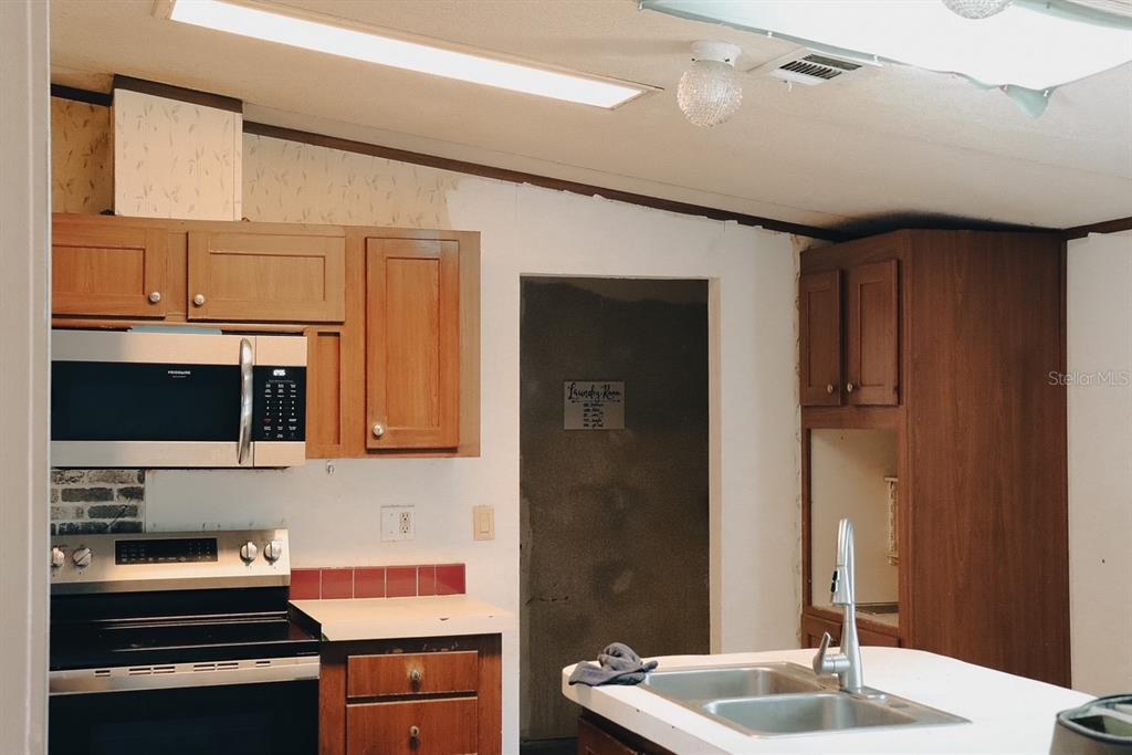 448 Fernandez Street Winter Haven, FL 33880 - Photo 5 of 27 a kitchen with stainless steel appliances a sink stove and cabinets