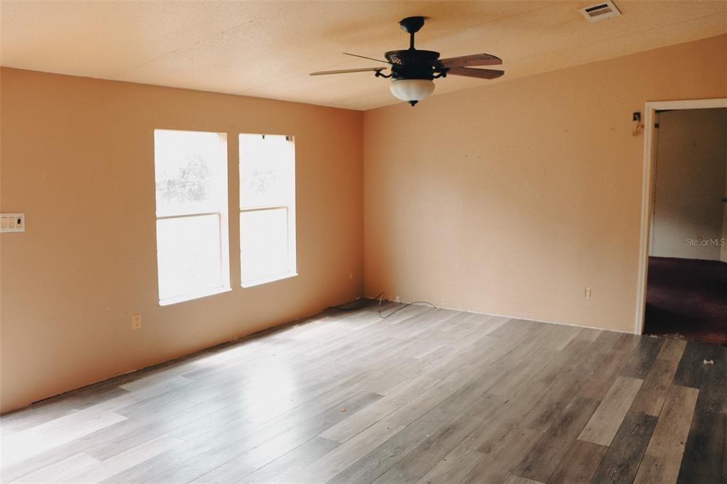 448 Fernandez Street Winter Haven, FL 33880 - Photo 9 of 27 a view of an empty room with a window and wooden floor