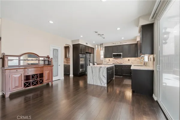 a kitchen with stainless steel appliances granite countertop a sink a stove and a refrigerator