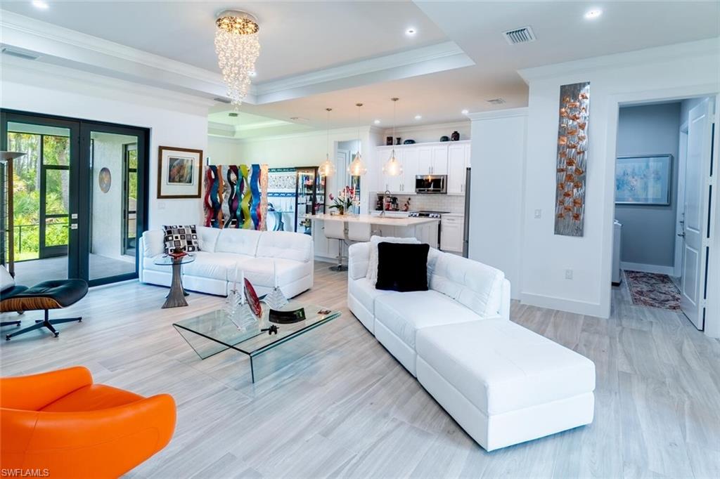 2572 Randall Boulevard Naples, FL 34120 - Photo 12 of 45 a living room with furniture and a wooden floor