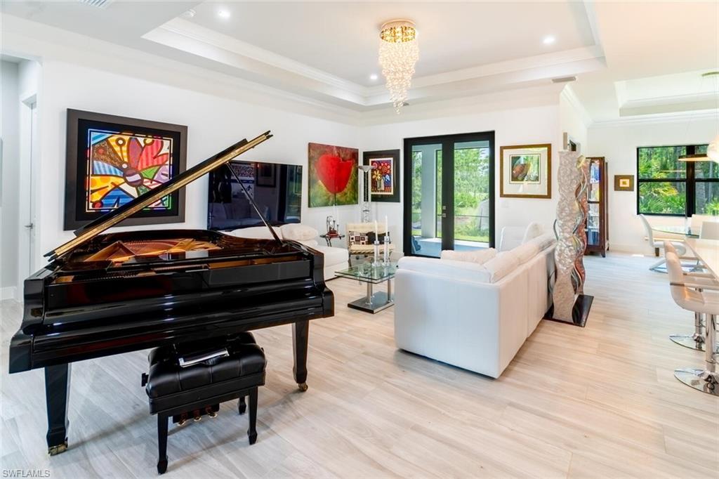 2572 Randall Boulevard Naples, FL 34120 - Photo 15 of 45 a living room with furniture and a flat screen tv