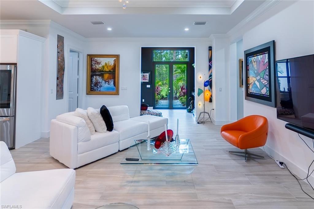 2572 Randall Boulevard Naples, FL 34120 - Photo 16 of 45 a living room with furniture and a flat screen tv