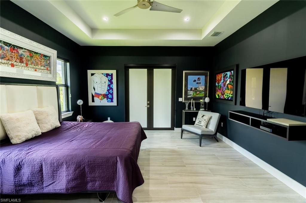 2572 Randall Boulevard Naples, FL 34120 - Photo 23 of 45 a bedroom with a bed and wooden floor