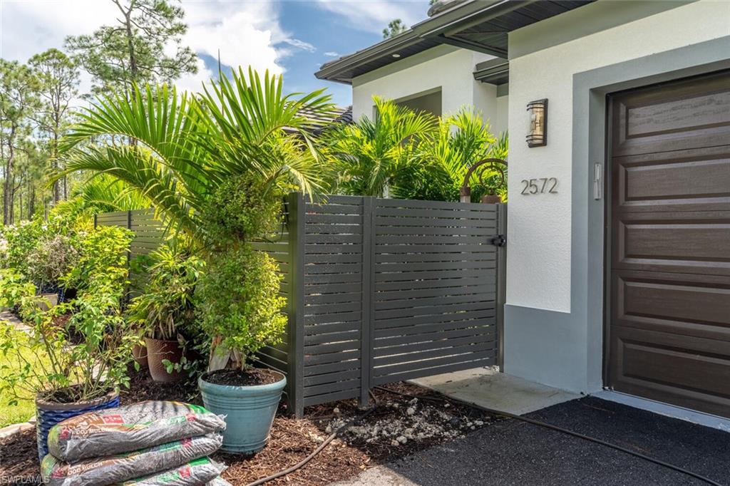 2572 Randall Boulevard Naples, FL 34120 - Photo 4 of 45 a view of house with chair and potted plants