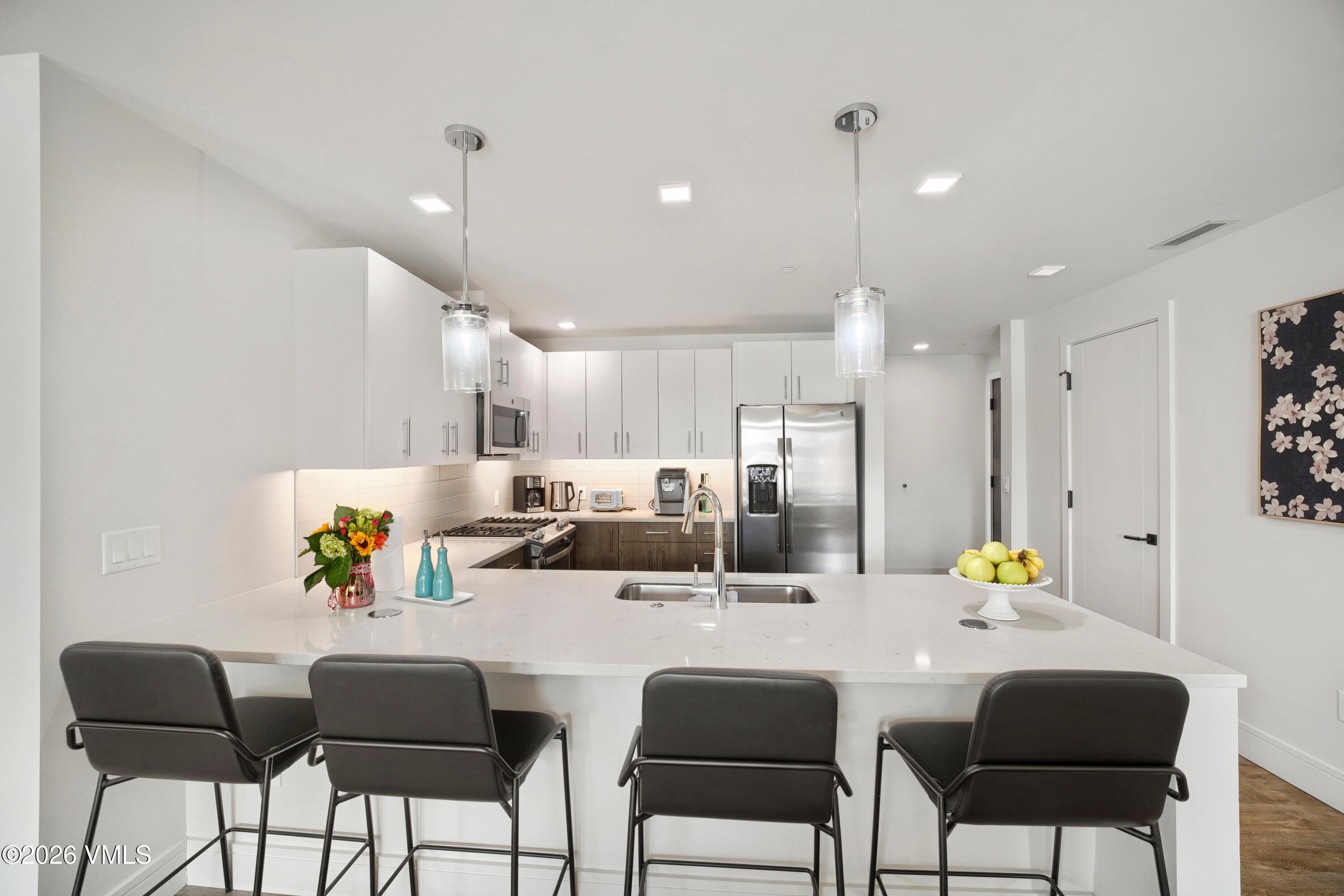 430 South Frontage Road East, Unit RUE Vail, CO 81657 - Photo 12 of 24 a kitchen with a dining table chairs refrigerator and cabinets