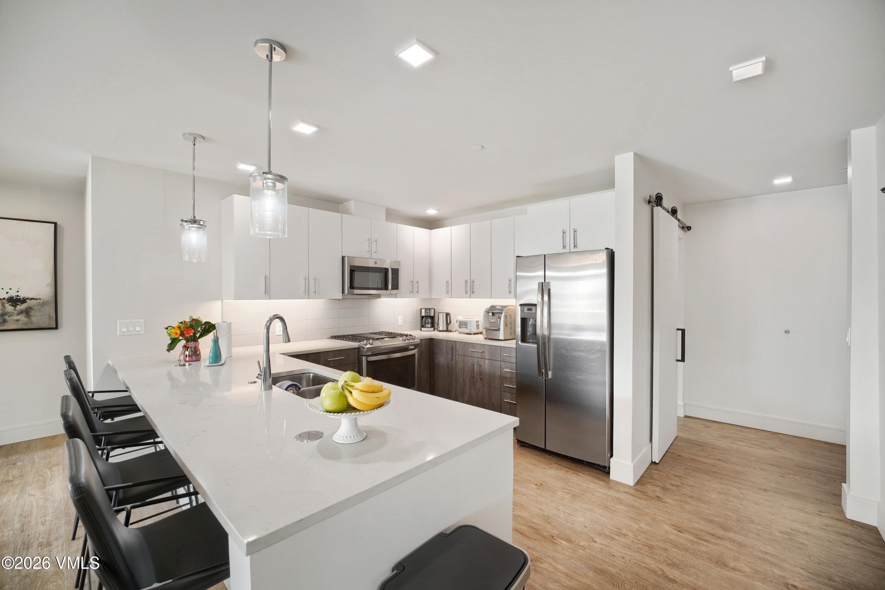 430 South Frontage Road East, Unit RUE Vail, CO 81657 - Photo 8 of 24 a kitchen with stainless steel appliances a refrigerator a stove a sink dishwasher a oven with white cabinets and wooden floor