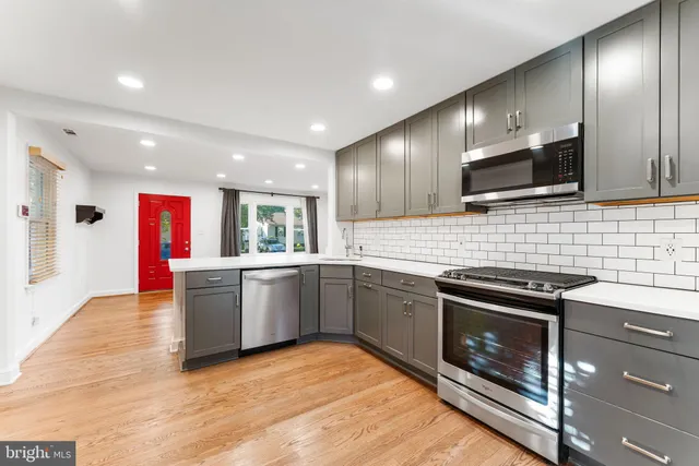 a kitchen with stainless steel appliances kitchen island granite countertop a stove and a sink