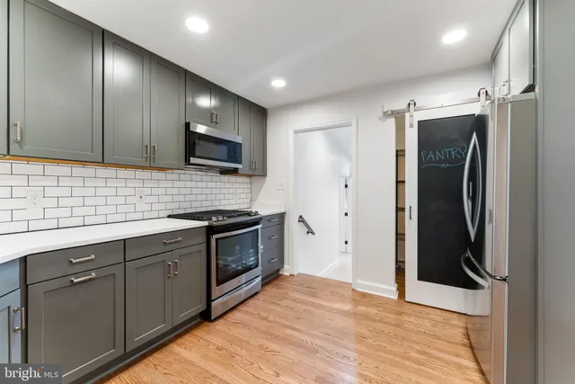 a kitchen with stainless steel appliances granite countertop a refrigerator and a sink