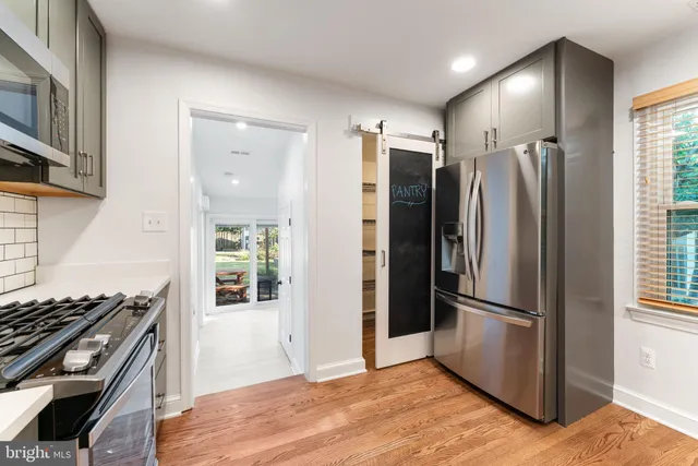 a kitchen with stainless steel appliances granite countertop a refrigerator and a stove top oven
