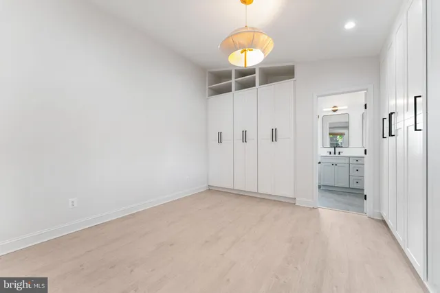 an empty room with closet and windows