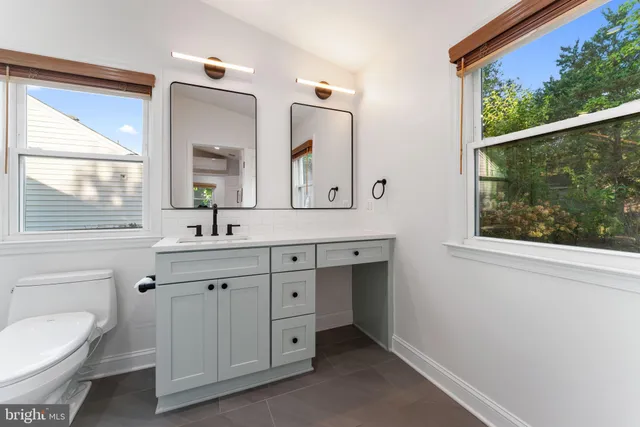 a bathroom with a shower sink vanity mirror and toilet