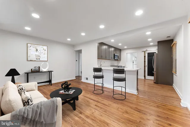 a living room with furniture and kitchen view
