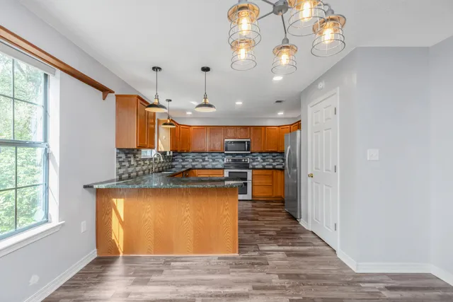 a view of a living room and kitchen with wooden floor