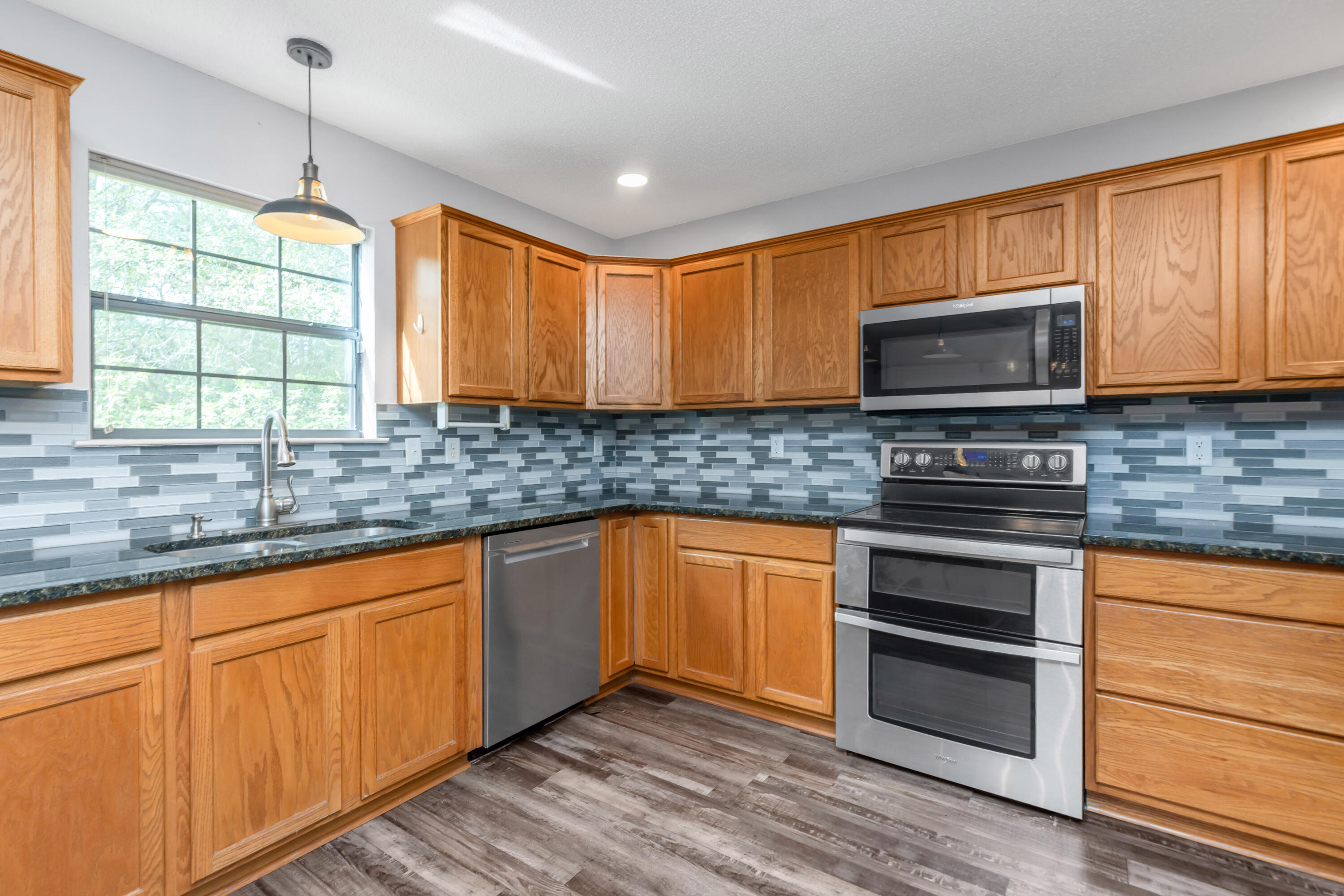 5825 Old Bethel Road Crestview, FL 32536 - Photo 14 of 44 a kitchen with stainless steel appliances granite countertop wooden cabinets sink and a granite counter top