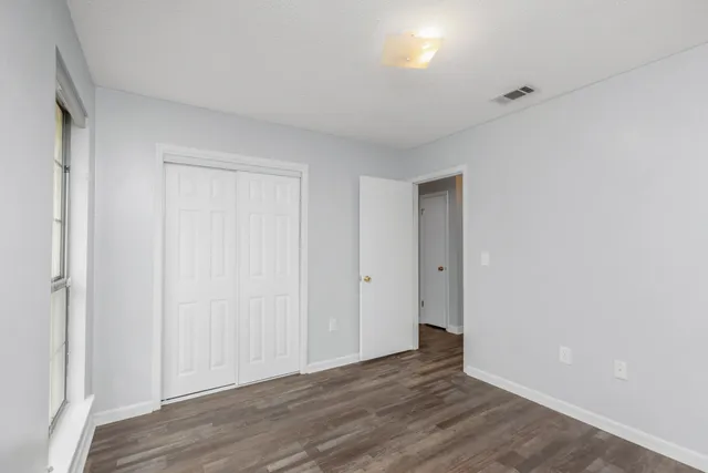 a view of an empty room with wooden floor