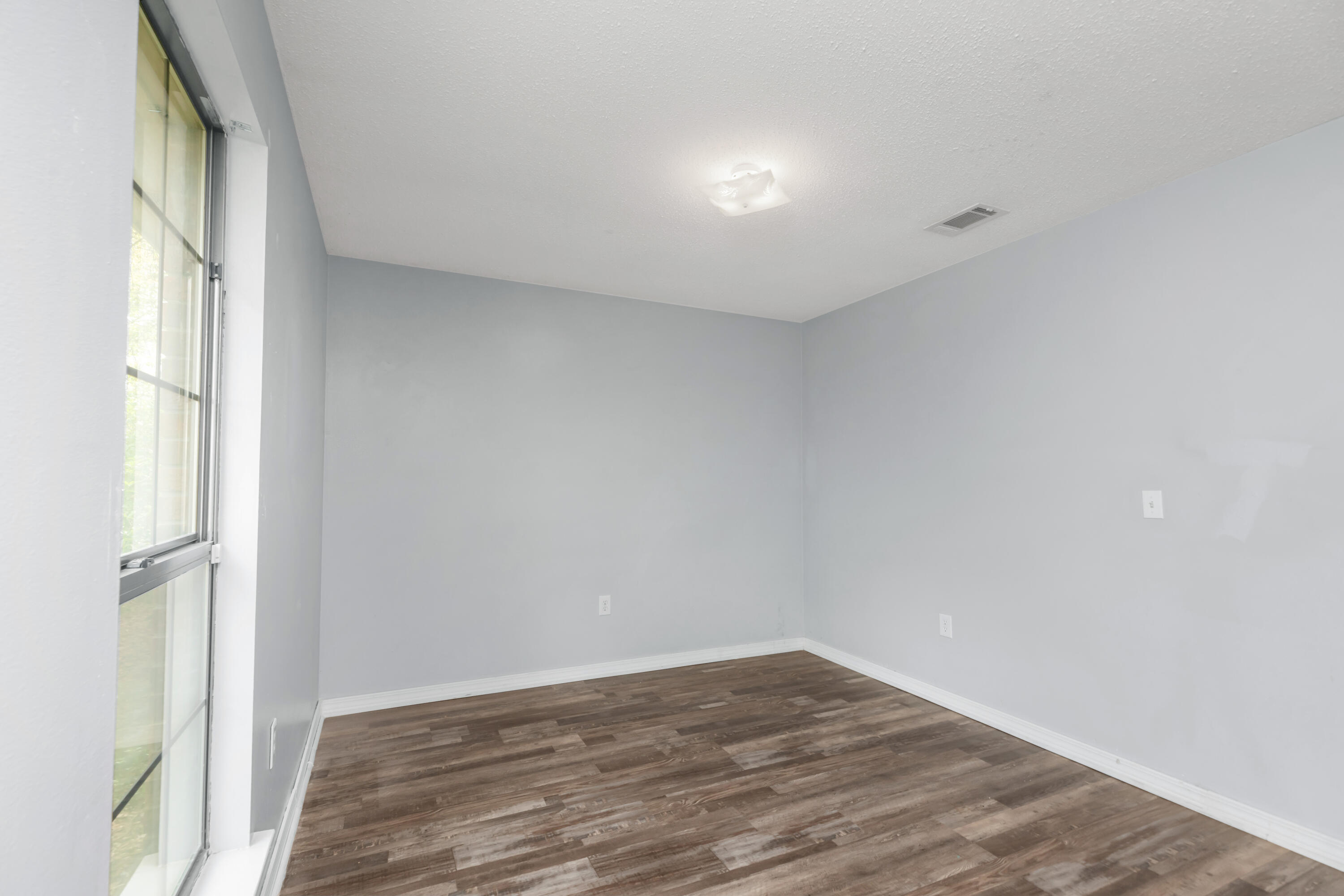 5825 Old Bethel Road Crestview, FL 32536 - Photo 23 of 44 a view of an empty room with wooden floor and a window