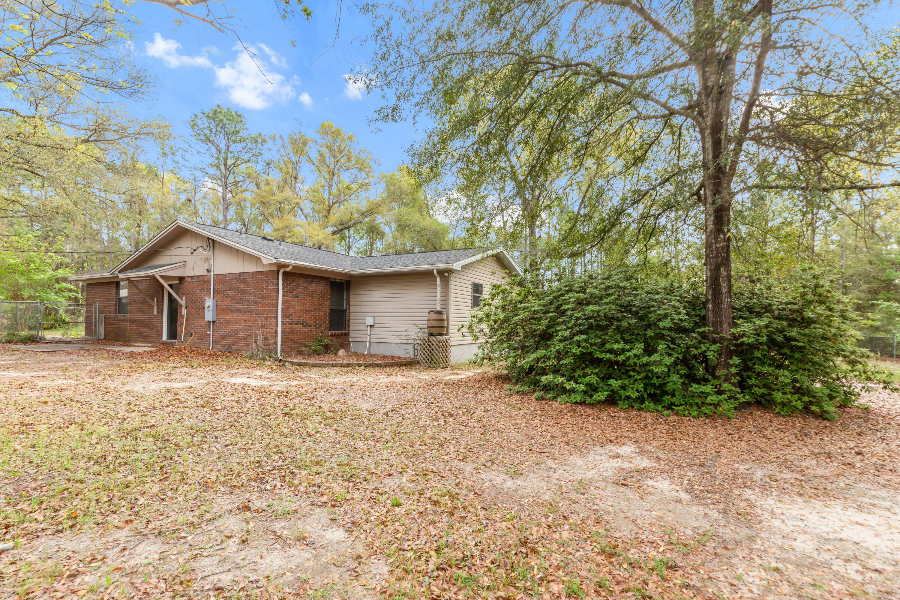 5825 Old Bethel Road Crestview, FL 32536 - Photo 33 of 44 a backyard of a house with large trees and wooden fence