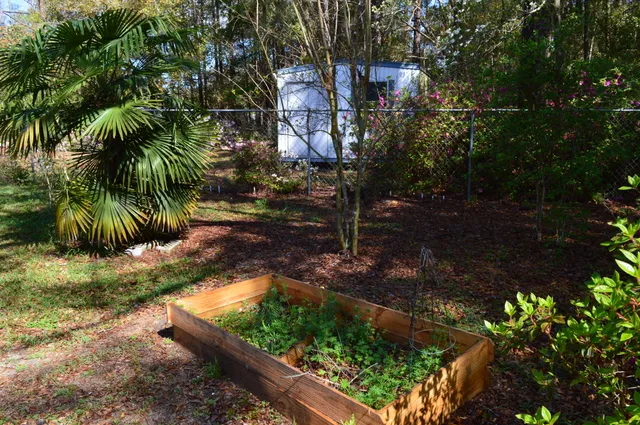 a view of a house is covered with flower plants
