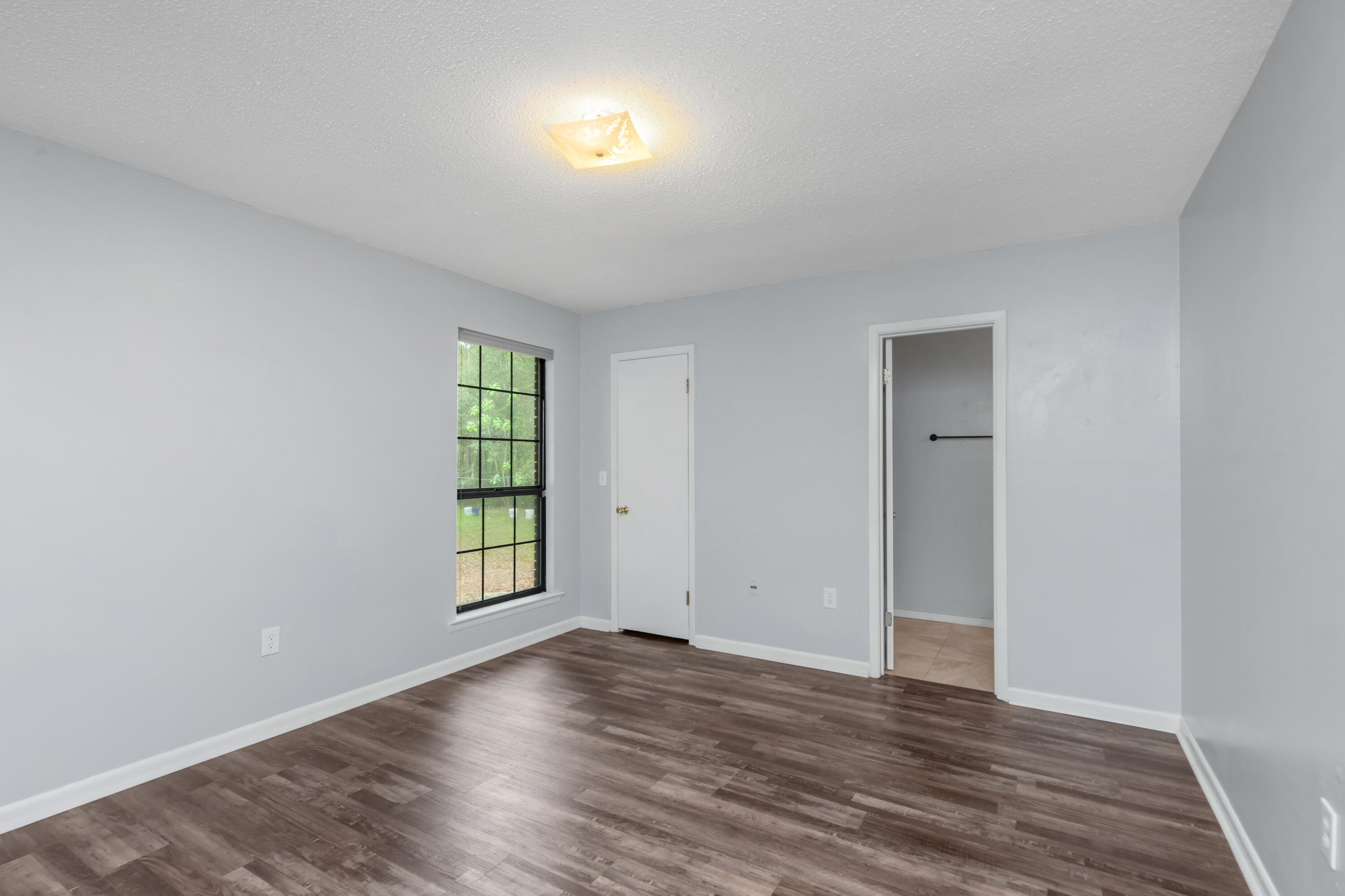5825 Old Bethel Road Crestview, FL 32536 - Photo 6 of 44 an empty room with wooden floor and windows