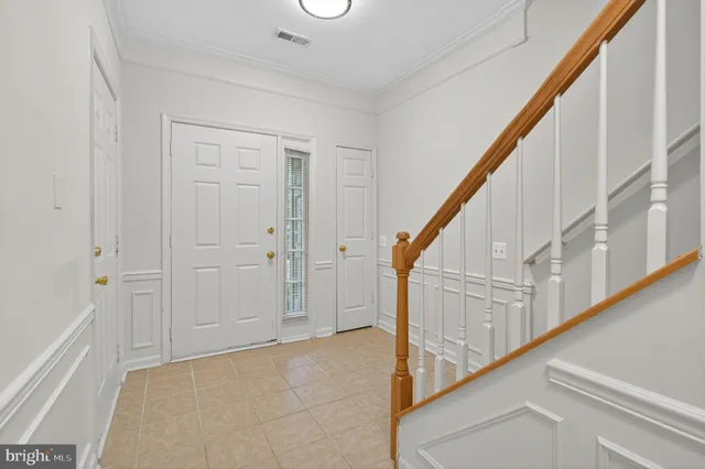 a view of staircase with lots of frames on wall and wooden floor