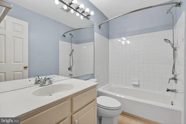 a bathroom with a sink a toilet a mirror a bathtub and shower