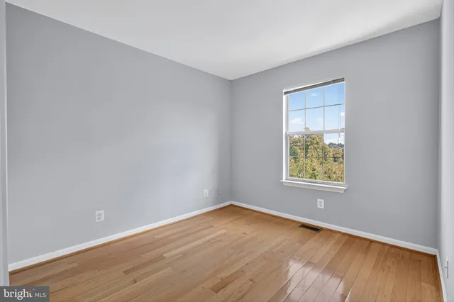 an empty room with wooden floor and a window