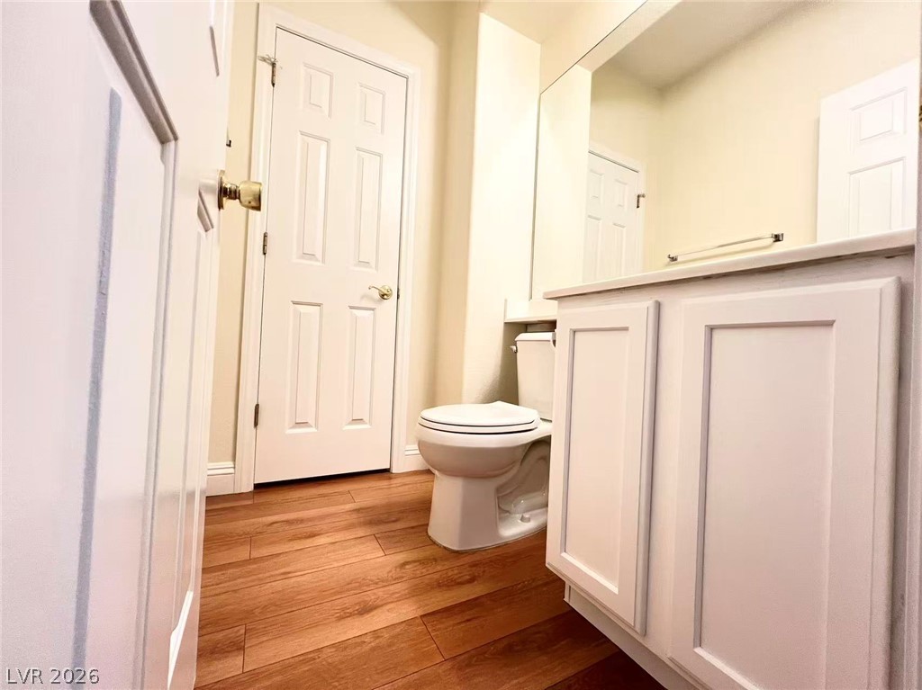 9891 Ridge Hill Avenue Las Vegas, NV 89147 - Photo 13 of 29 Hardwood floors and a pristine vanity create a functional, modern bathroom space.