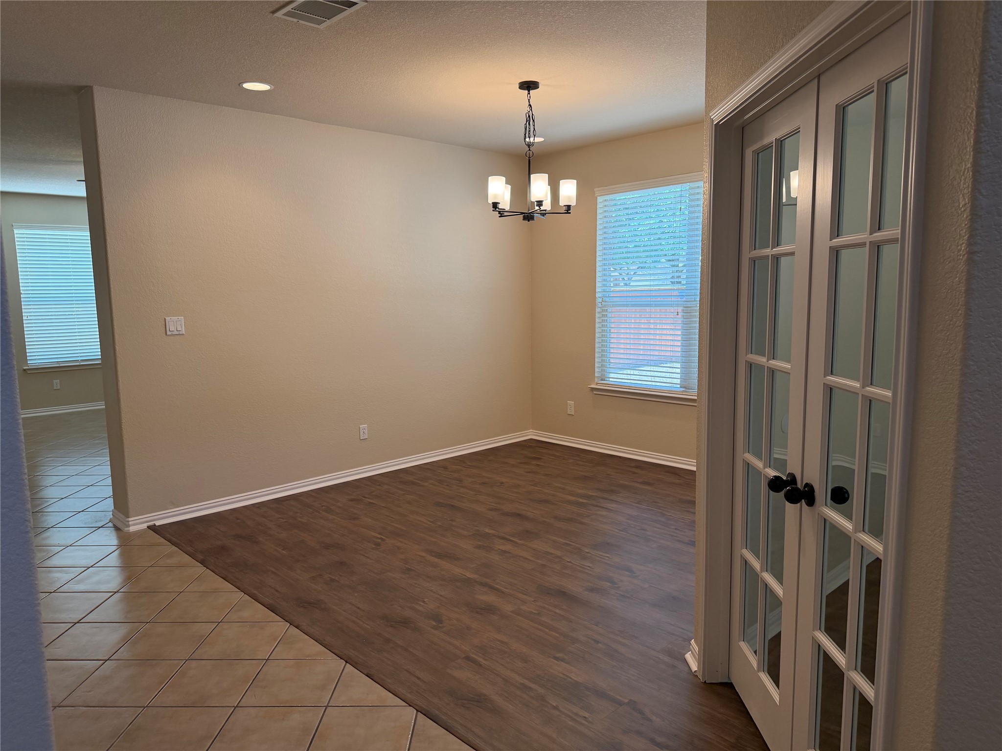 3021 Grand Mission Way Pflugerville, TX 78660 - Photo 4 of 31 French doors open to this versatile room, featuring rich hardwood floors and abundant natural light.