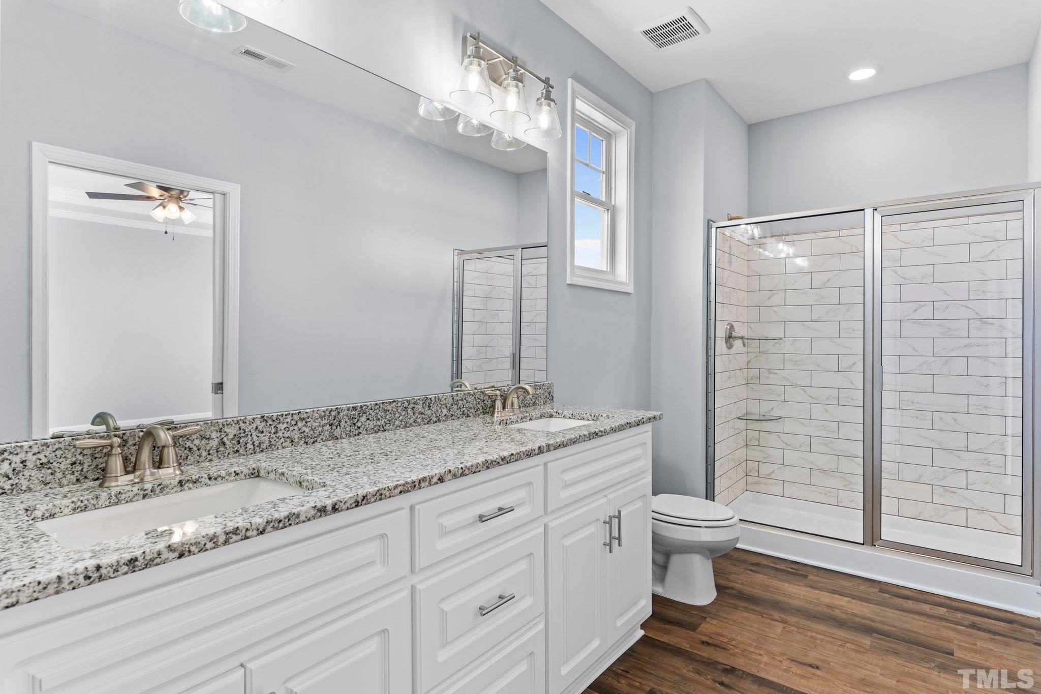 9695 Chapman Road Bailey, NC 27807 - Photo 20 of 26 a bathroom with a granite countertop sink a toilet and shower