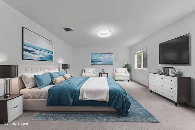 a bedroom with a large bed and a flat screen tv