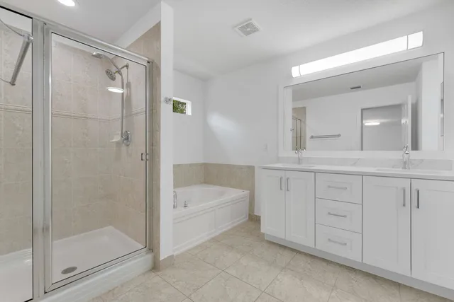 a bathroom with a granite countertop sink a mirror a bathtub and shower